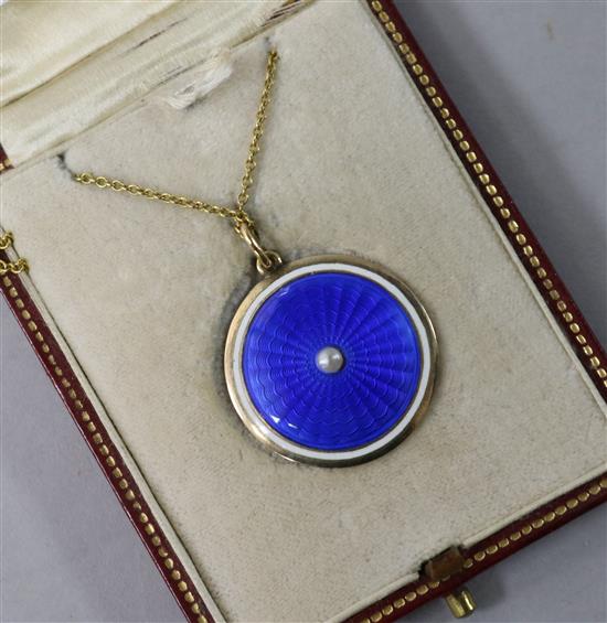 An Edwardian gold, blue guilloche enamel and split pearl circular pendant locket, on a 15ct gold fine link chain, pendant 21mm.